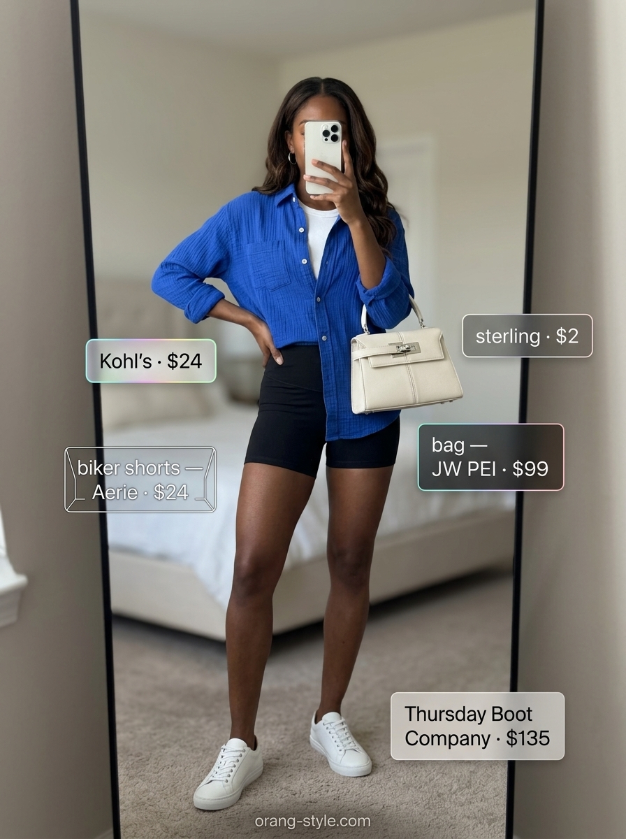 Black biker shorts outfits summer for women 2026: Bold Contrast with cobalt blue shirt and white sneakers.