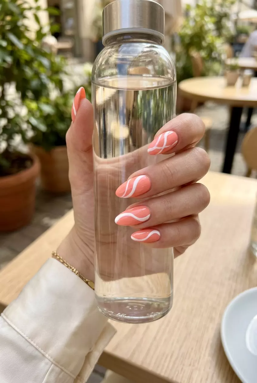 Almond Summer Nails 2026: Coral Swirl Energy Almond summer nails 2026 for fair skin: Light coral with abstract white swirls for energetic vibes.
