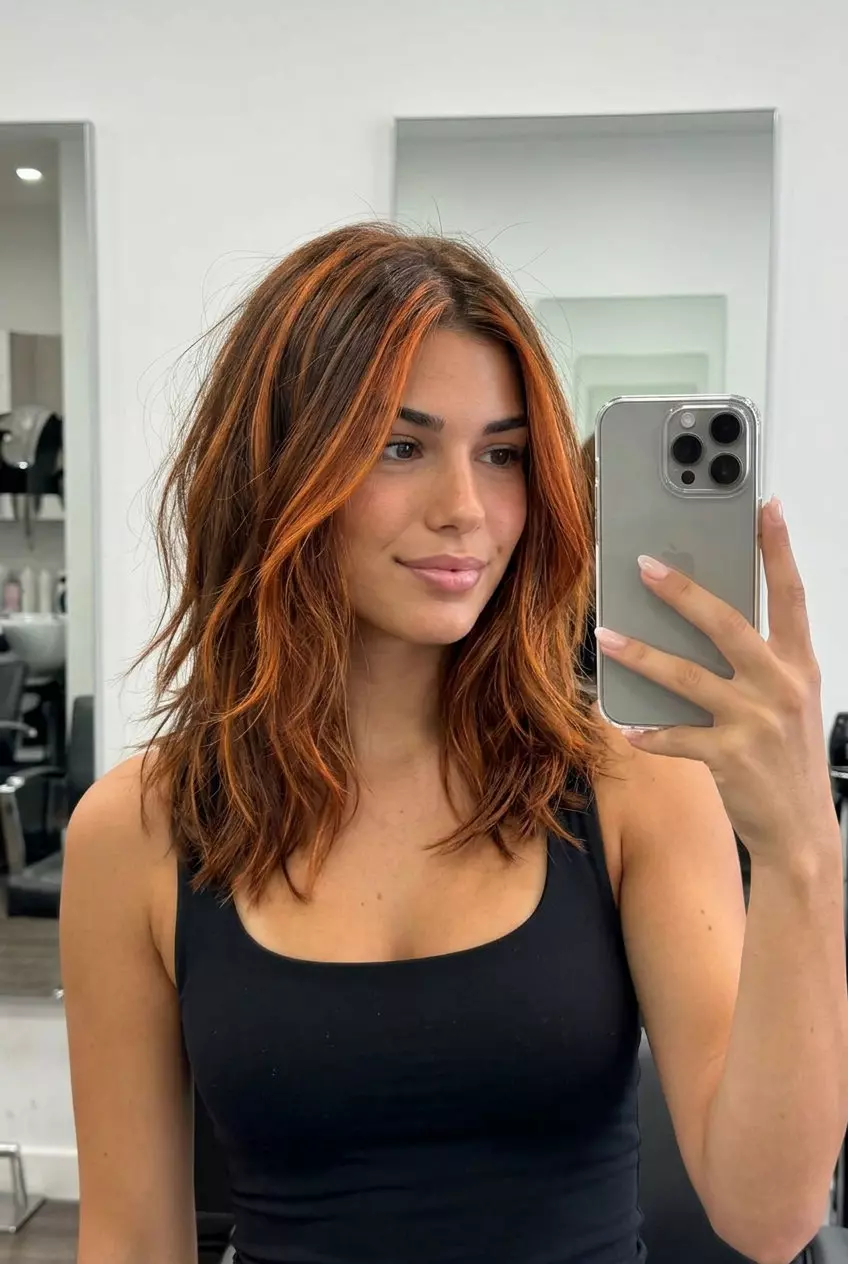 long textured layers with copper penny accents on deep brunette, chunky highlights, no fringe &mdash; edgy festival look