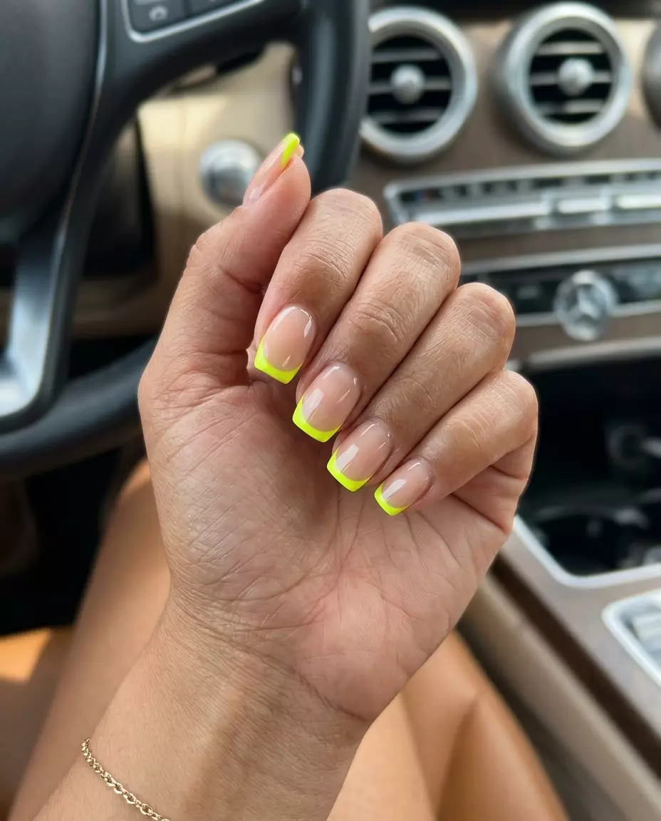 Chic nude nails with fluorescent yellow reverse French tips for daily wear. Neon summer nails 2026.