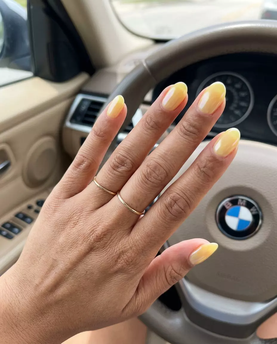 Oval Summer Nails 2026: Buttercup Glazed Donut Whimsical oval summer nails 2026 in buttercup yellow with a glazed donut pearlescent finish.