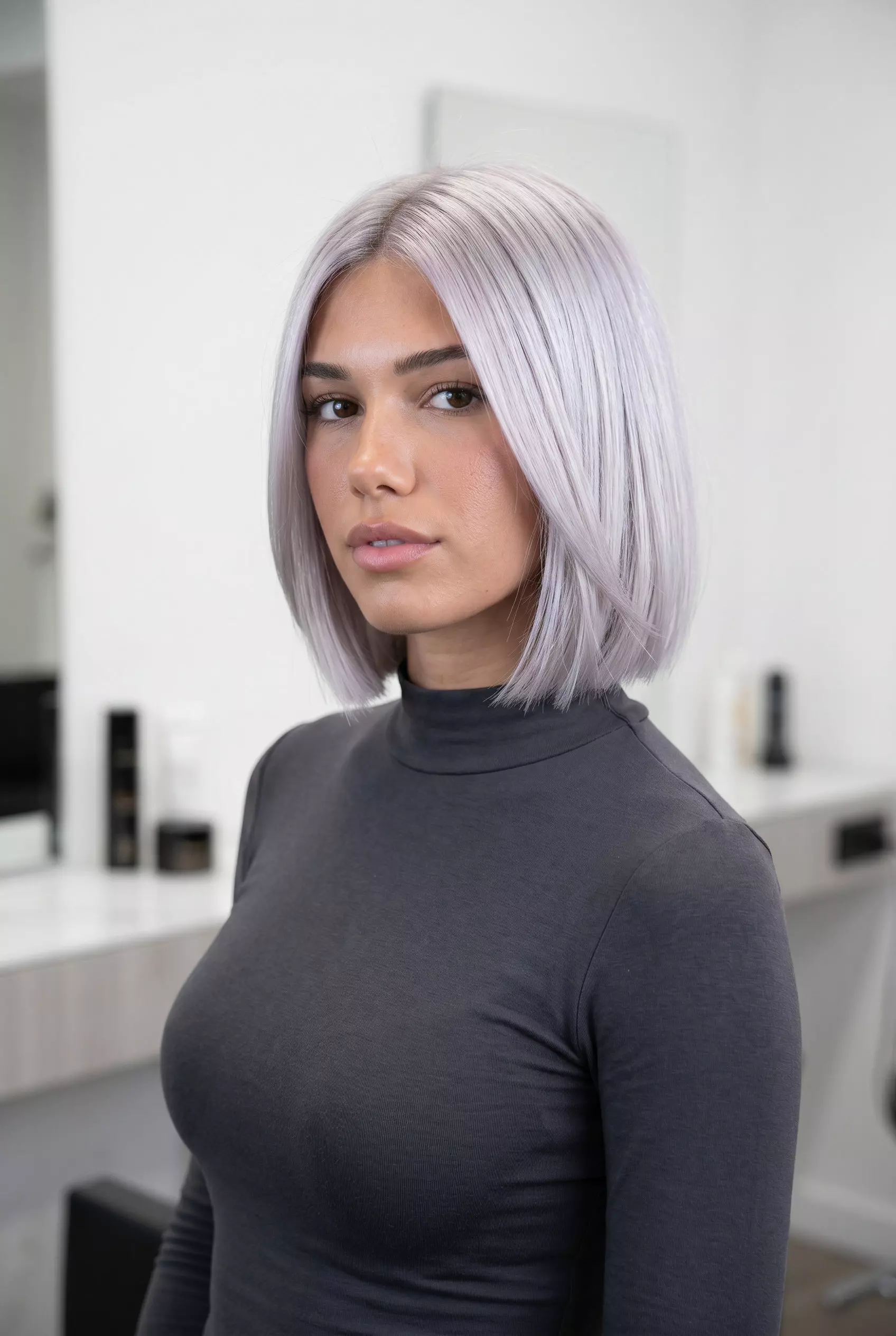 chin-length textured bob haircut with icy platinum blonde silver tones and razor-cut perimeter for an edgy look