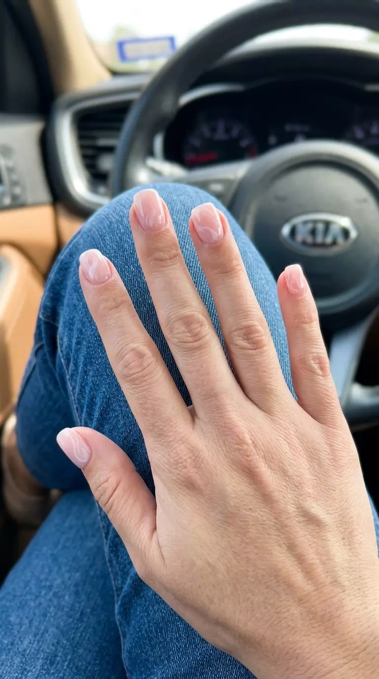 Romantic Milk Bath Nails 2026 Simple short summer nails 2026: Romantic milky pink nails with delicate white swirls for weddings.