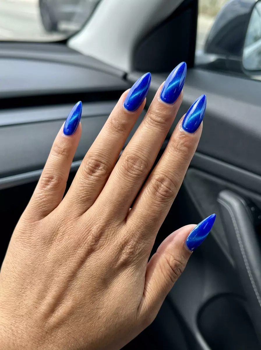 Futuristic electric cobalt cat-eye stiletto nails for night outs and festivals 2026.