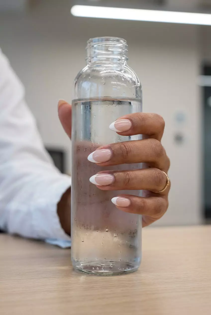 Clean French tip stiletto nails in sheer nude and milky white for minimalist style 2026.