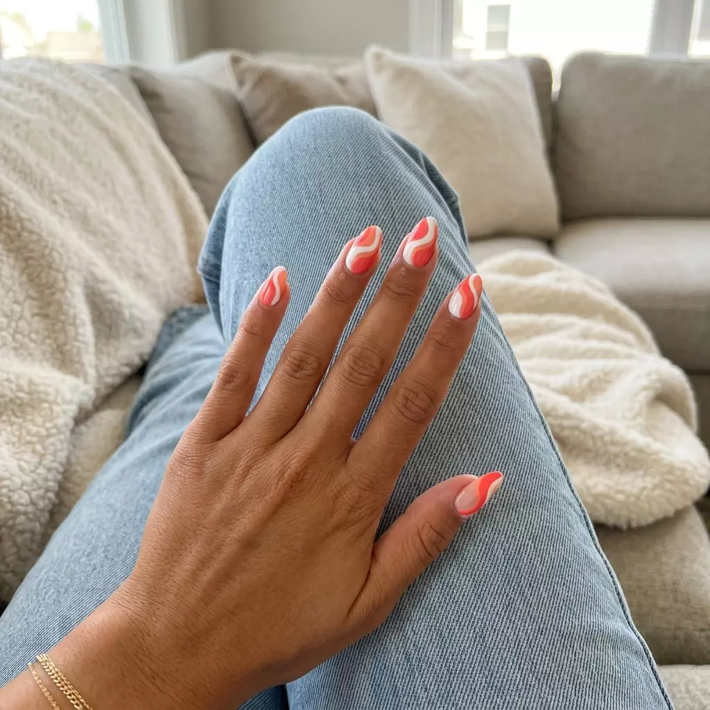 Coral Swirl Birthday Nails 2026 Coral Swirl Summer Bliss Almonds: Playful coral and white swirls on nude gel nails for summer birthday nails 2026.