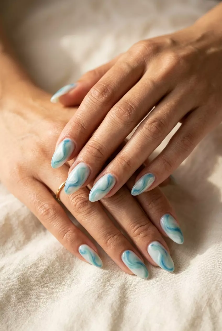 Ocean Swirl Cat Eye Milky Nails 2026 Ocean Swirl Cat Eye Milky nails for summer 2026: Bohemian medium oval nails with blue/seafoam green swirls and magnetic shift.