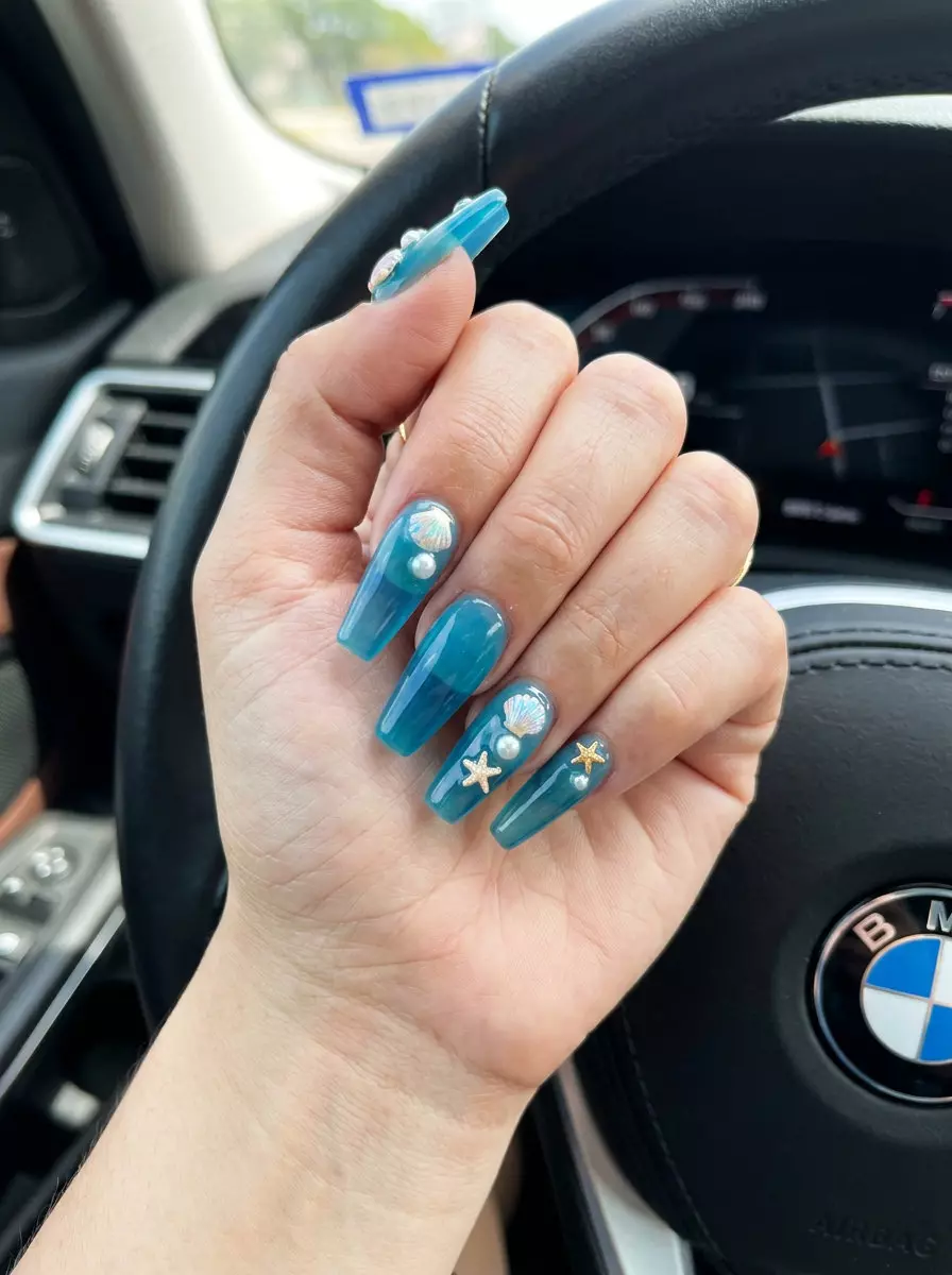 Oceanic Charm Coffin Nails 2026 Oceanic Charm Fantasy Coffin nails: translucent ocean blue jelly with pearl seashell charms. Summer colorful nails designs 2026.