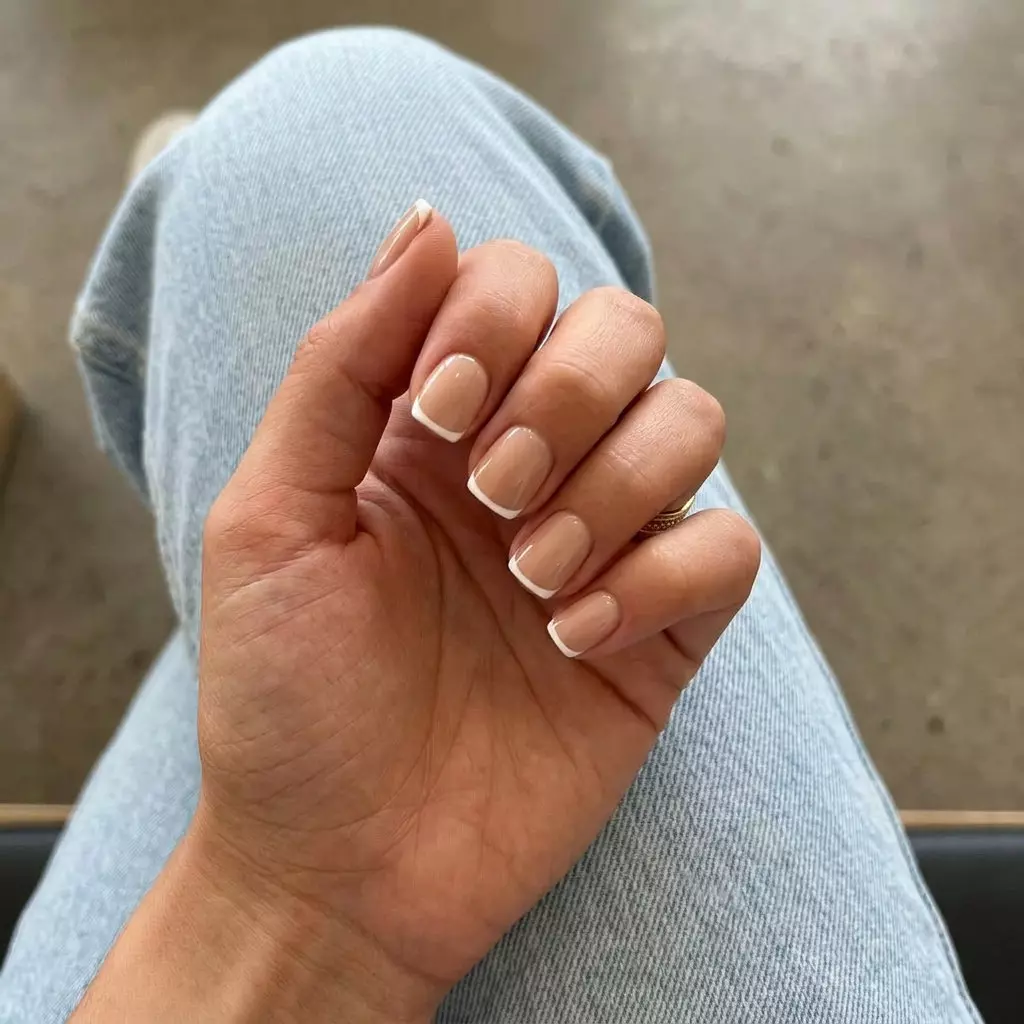 Nude Beige Micro French: Polished summer nail colors 2026 for work. Minimalist nude & white tip.