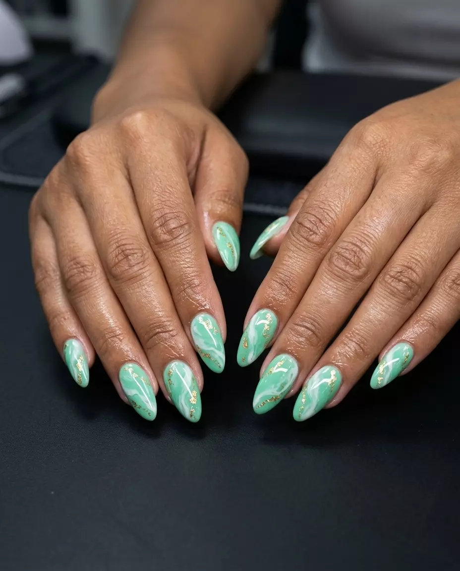 Artistic mint green abstract marble nails with gold foil for summer nails 2026, glamorous for parties.
