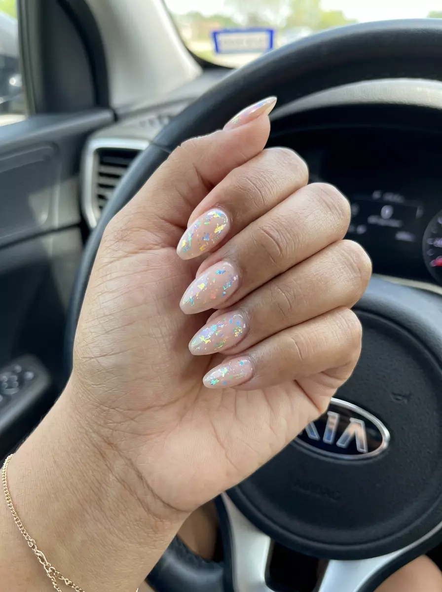Bohemian Rainbow Nails 2026: Festival Style Bohemian rainbow foil flake nails 2026: Milky nude with iridescent scattered foil flakes for vacation.