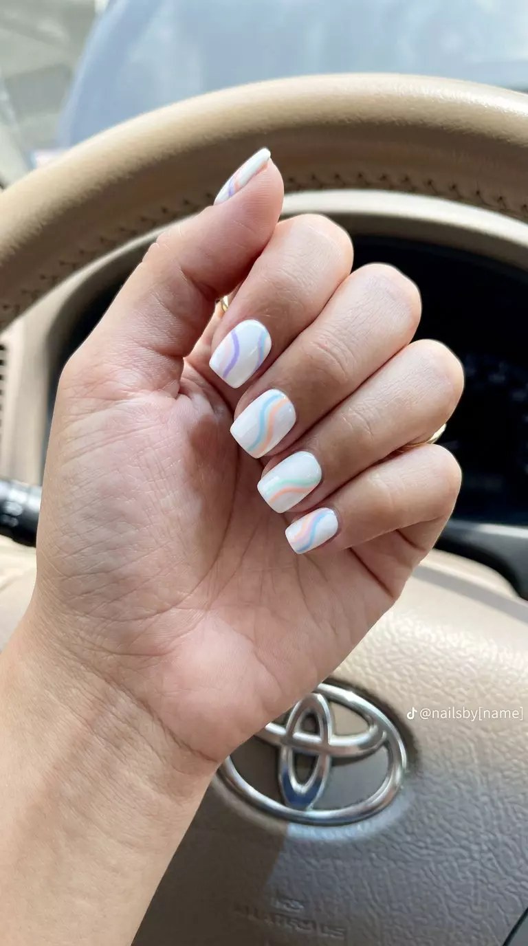 Minimalist Rainbow Lines Nails 2026 Chic white nails with minimalist pastel rainbow lines for summer rainbow nails 2026. Ideal for work and casual outings.