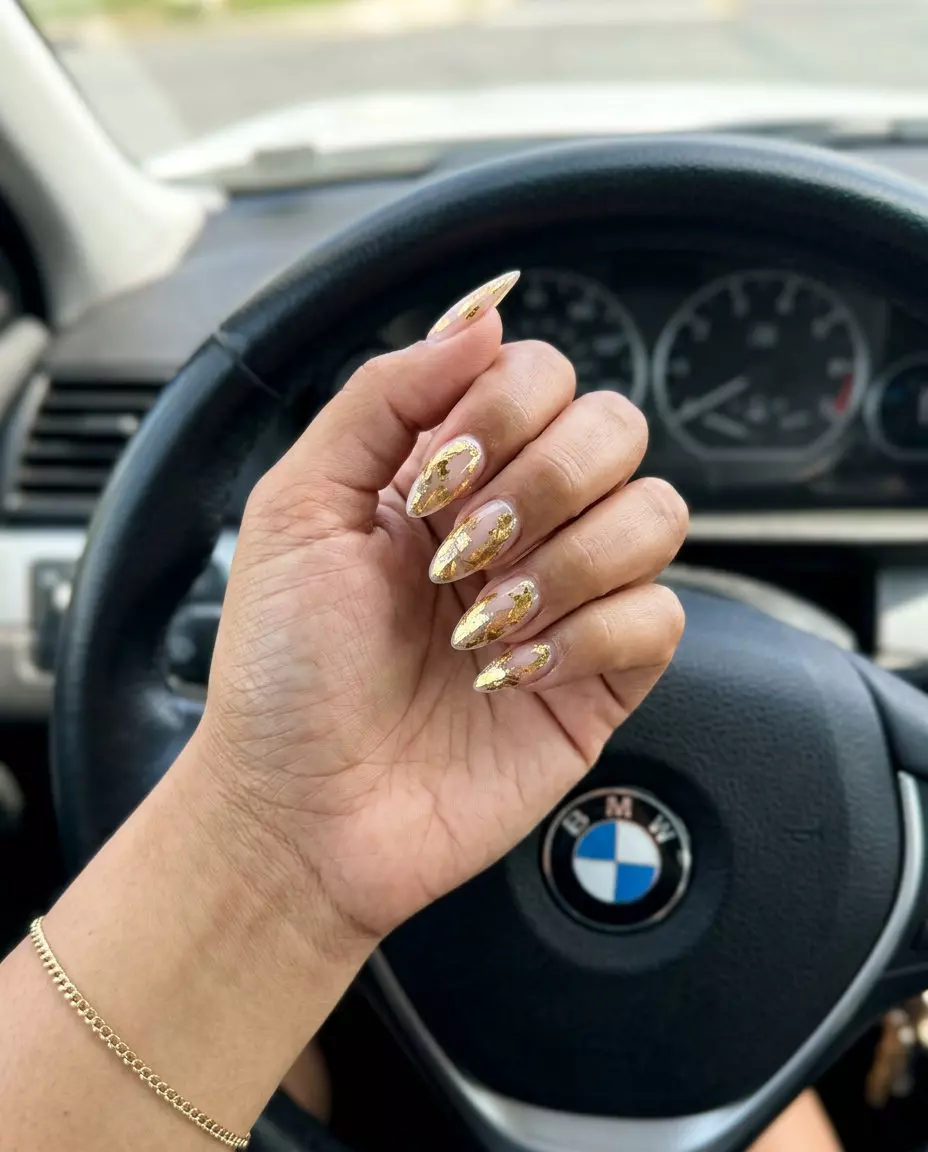 Trendy summer nails 2026: Luxurious liquid gold foil accents on almond shape for formal events.