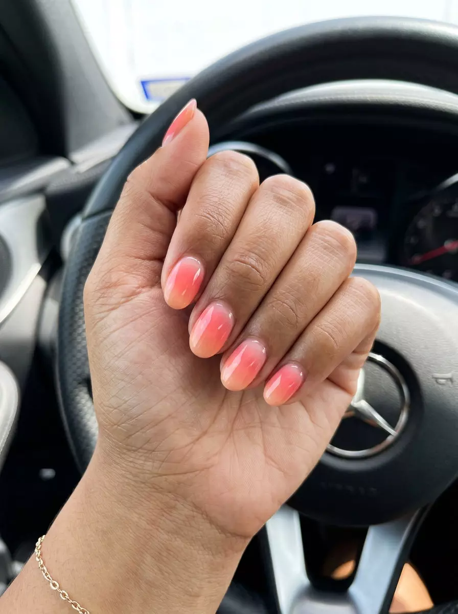 Trendy summer nails 2026: Romantic sunset coral aura gradient on oval nails for date night.